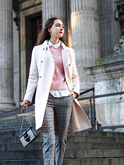 A woman walks past the London train station in a pair of striped gray Oasis women's slacks.