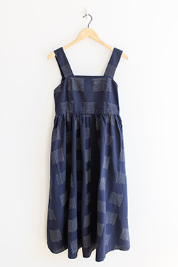 A striped navy blue Oasis women's sundress hangs from a hanger.