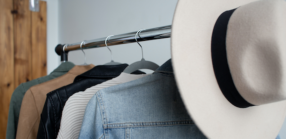 The womens section of the Oasis store displays a rack of colorful sweaters and jackets, and a soft fedora hat